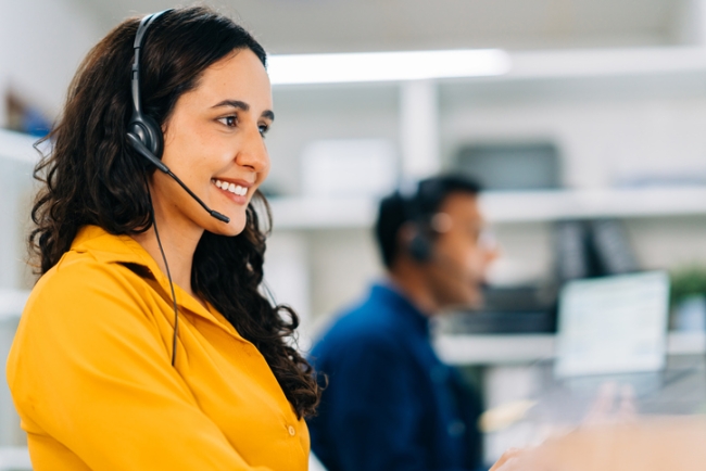 Female customer support agent assisting client over the phone.